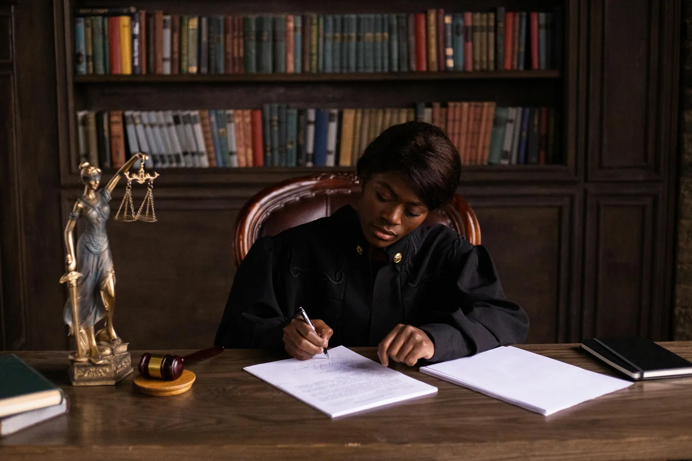 Judge reviewing case documents at a desk with the scales of justice nearby, the courtroom decision-making the deadline-driven filing preserves